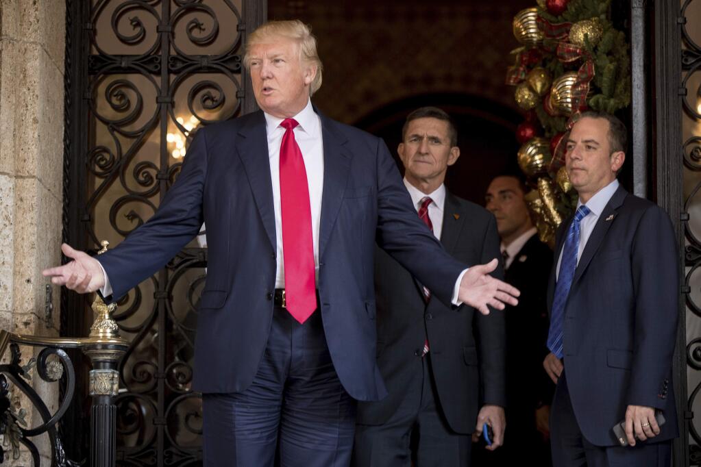 President-elect Donald Trump, left, accompanied by Trump Chief of Staff Reince Priebus, right, and Retired Gen. Michael Flynn, a senior adviser to Trump, center, speaks to members of the media at Mar-a-Lago, in Palm Beach, Fla., Wednesday, Dec. 21, 2016. (AP Photo/Andrew Harnik)