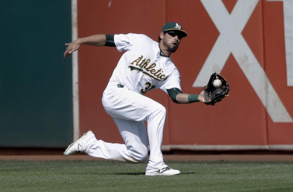 In this Sunday, Sept. 11, 2016, file photo, Oakland Athletics center fielder Brett Eibner makes a sliding catch on a fly ball from Seattle Mariners' Dae-Ho Lee during the eighth inning. (AP Photo/Marcio Jose Sanchez, File)