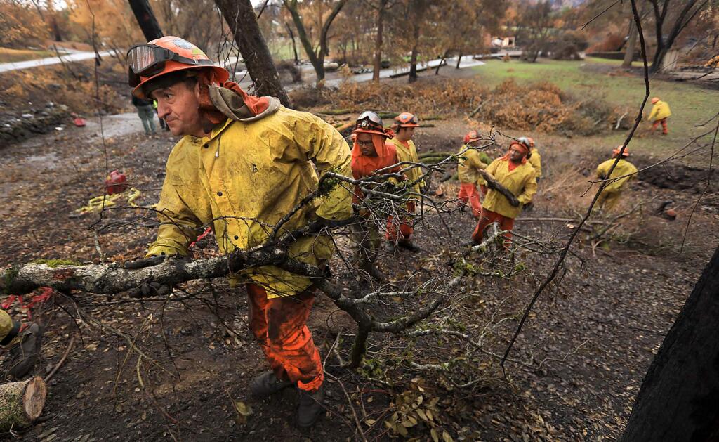 Inmates from Konocti's Cal Fire's California Department of Corrections fire crew clear fire damaged trees along Riebli Road and a tributary of Mark West Creek, Wednesday Nov. 15, 2017 near Santa Rosa, in anticipation of heavy rain. (Kent Porter / Press Democrat) 2017