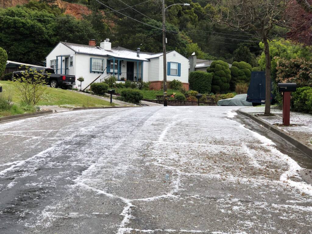 Hail covers Belfast Street in Oakland Calif., after a storm on Monday, April 16, 2018, in Oakland, Calif. Hail is covering highways and streets in the San Francisco Bay Area and snow is falling in the Sierra Nevada as a spring storm moves through Northern California. (Laura Oda/San Jose Mercury News via AP)