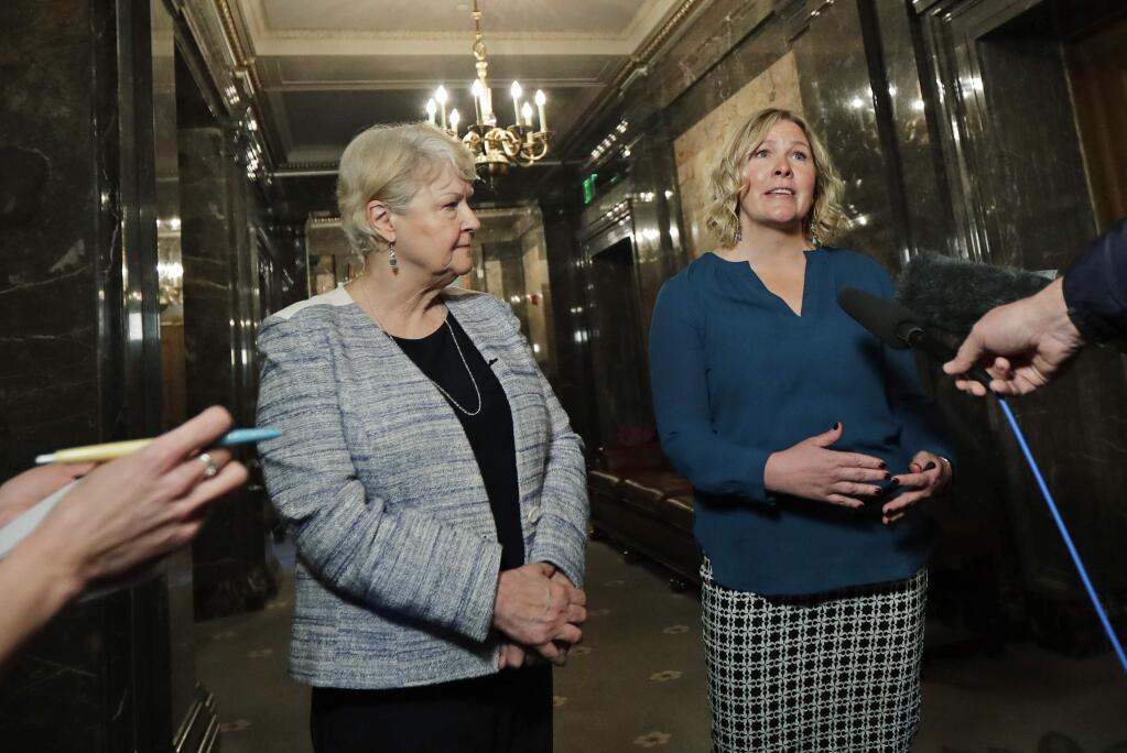 In this March 21, 2018, photo, Rebecca Johnson, right, a lobbyist who helped organize a letter signed by more than 200 women calling for a culture change at the Washington state Capitol, talks to reporters as Sen. Karen Keiser, D-Des Moines, left, looks on in Olympia, Wash. Washington's legislative session is over but the conversation about sexual harassment at the state Capitol continues, with the House and Senate each convening their own groups to discuss potentials codes of conduct and how to address complaints. (AP Photo/Ted S. Warren)