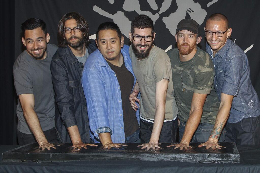 FILE - In this June 18, 2014 file photo, members of Linkin Park, from left, Mike Shinoda, Rob Bourdon, Joe Hahn, Brad Delson, Dave Farrell and Chester Bennington attend an induction ceremony for the Guitar Center's RockWalk at Guitar Center in Los Angeles. Linkin Park said their hearts are broken following the death of Bennington, who died by hanging last week. The rock band said Monday, July 24, 2017, the “shockwaves of grief and denial are still sweeping through our family as we come to grips with what has happened.” (Photo by Paul A. Hebert/Invision/AP, File)