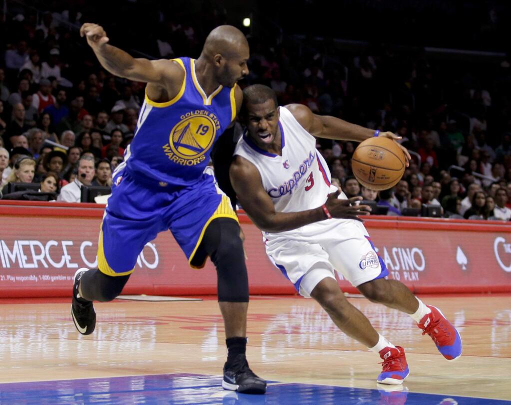 Los Angeles Clippers guard Chris Paul, right, drives around Golden State Warriors guard Leandro Barbosa during the first half of an NBA basketball preseason game in Los Angeles, Tuesday, Oct., 7, 2014. (AP Photo/Chris Carlson)