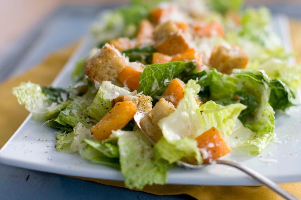 FILE - This Jan. 24, 2012, file photo shows a plate of butternut Caesar salad with Romaine lettuce and roasted cubes of butternut squash. U.S. health officials say the E. coli outbreak linked to tainted romaine lettuce has grown and sickened 84 people from 19 states. The U.S. Centers for Disease Control said Wednesday, April 25, 2018, that at least another 31 cases are believed to be tied to romaine lettuce grown in Yuma, Arizona. (AP Photo/Matthew Mead, File)