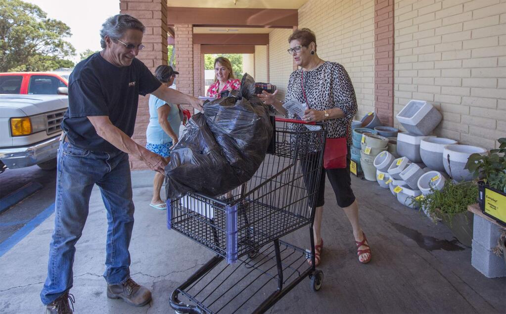 At the Safeway grocery store on West Napa St., City Council member Madolyn Agrimonti steers a shopping cart being filled with recyclables by Dave Opatz. (Photo by Robbi Pengelly/Index-Tribune)