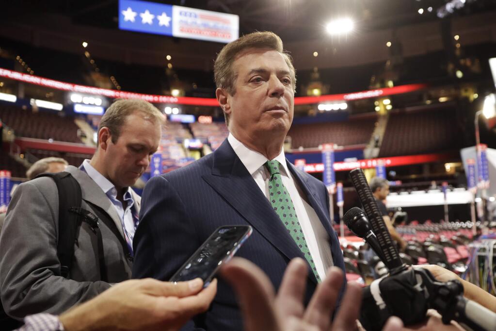 FILE - In this July 17, 2016, file photo, Paul Manafort talks to reporters on the floor of the Republican National Convention at Quicken Loans Arena in Cleveland. Manafort, President Donald Trump's former campaign chairman secretly worked for a Russian billionaire to advance the interests of Russian President Vladimir Putin a decade ago and proposed an ambitious political strategy to undermine anti-Russian opposition across former Soviet republics, The Associated Press has learned. (AP Photo/Matt Rourke, File)