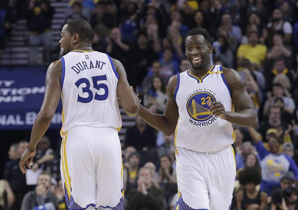 Golden State Warriors forward Kevin Durant (35) is congratulated by forward Draymond Green (23) after scoring against the Detroit Pistons during the second half of an NBA basketball game in Oakland, Calif., Thursday, Jan. 12, 2017. (AP Photo/Jeff Chiu)