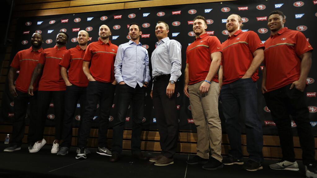 From left to right, San Francisco 49ers' Pierre Garçon, Marquise Goodwin, Robbie Gould, quarterback Brian Hoyer, head coach Kyle Shanahan, general manager John Lynch, Kyle Juszczyk, Logan Paulsen and Malcolm Smith stand for a photo at the end of a media conference Friday, March 10, 2017, in Santa Clara, Calif. (AP Photo/Ben Margot)
