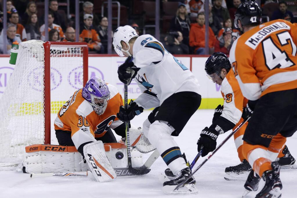 The Philadelphia Flyers' Michal Neuvirth (30) blocks a shot by the San Jose Sharks' Joonas Donskoi (27) as Ivan Provorov (9) and Andrew MacDonald (47) defend during the first period Tuesday, Nov. 28, 2017, in Philadelphia. (AP Photo/Matt Slocum)
