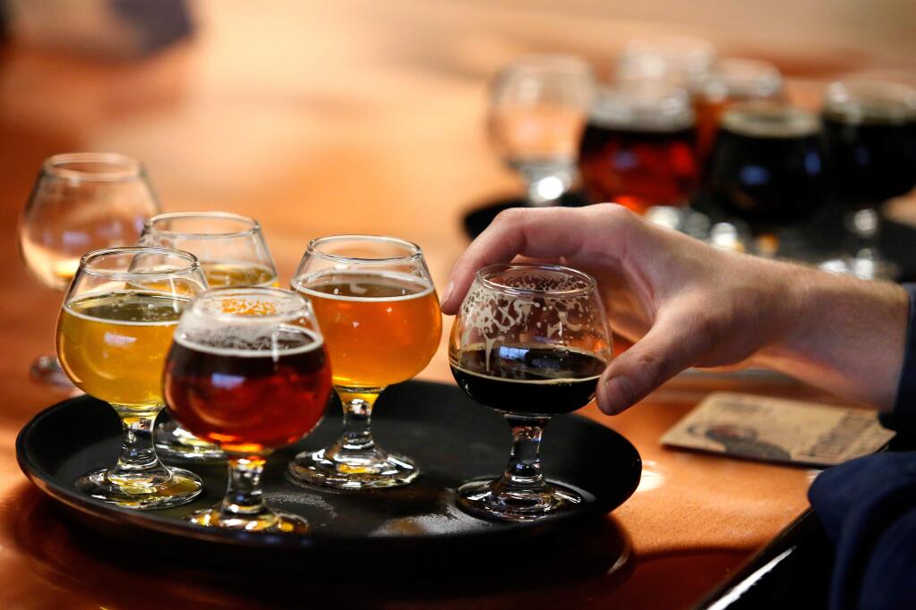 A selection of HenHouse Brewing Company's beers is served on the copper surface of the new tasting room bar built by co-founder Scott Goyne, during the opening of HenHouse's new brewery and tasting room in Santa Rosa, California on Friday, March 4, 2016. (Alvin Jornada / The Press Democrat)
