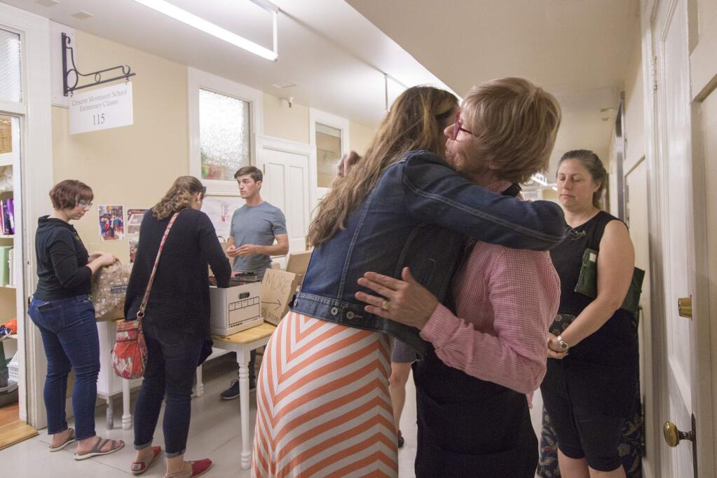 Karen Niehoff, director of The Crescent Montessori School of Sonoma, gets a hug from parent Rebecca Porrino., during the school's garage sale on Saturday, August 18. The school, housed at the Sonoma Community Center, has now closed most of its classes. (Photo by Robbi Pengelly/Index-Tribune)