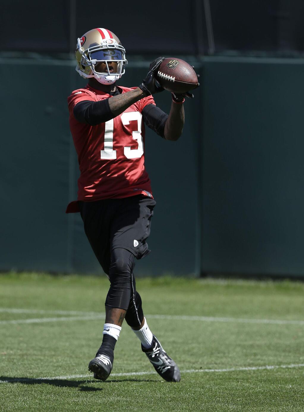In this June 17, 2014 file photo, San Francisco 49ers wide receiver Stevie Johnson (13) catches a pass during NFL football minicamp in Santa Clara. Johnson had produced three straight 1,000-yard seasons with 23 touchdown catches as Buffalo's most dynamic player in the passing game when that streak ended in frustrating fashion last year. There were injuries and the unexpected death of his mother. Now he has a chance to start a new streak with his new team, back home in the Bay Area. (AP Photo/Jeff Chiu, File)