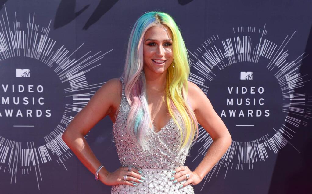 In this Aug. 24, 2014 file photo, Kesha arrives at the MTV Video Music Awards at The Forum in Inglewood, Calif. Kesha and her mentor and music producer, Dr. Luke, filed dueling lawsuits on Tuesday, Oct. 14, 2014, over the pop singer's recording contracts and her allegations that the producer sexually and emotionally abused her for several years. Dr. Luke's lawsuit calls the claims an extortion attempt by Kesha and her mother to gain a more favorable recording contract. (Photo by Jordan Strauss/Invision/AP, file)