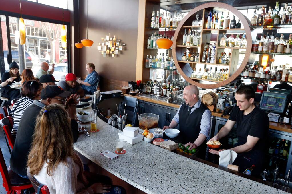 Bar manager Alex Kaplan, second from right, jokes with customers while preparing their drinks at Jackson's Bar and Oven in Santa Rosa, California on Tuesday, February 23, 2016. (Photo credit: Julie Grosse)