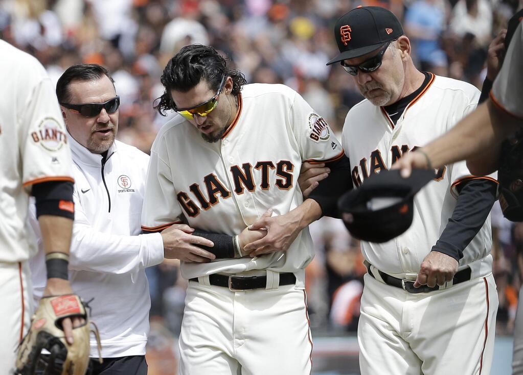 San Francisco Giants left fielder Jarrett Parker, center, walks off the field with trainer Dave Groeschner, left, and manager Bruce Bochy after catching a fly ball hit by Colorado Rockies' DJ LeMahieu during the fourth inning Saturday, April 15, 2017. Parker broke his collarbone on the play and left the game. (AP Photo/Jeff Chiu)