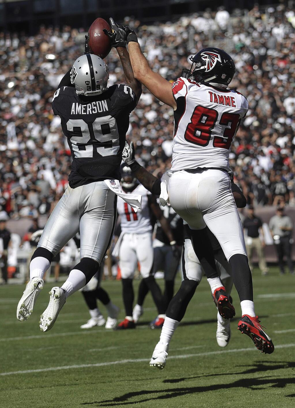 Oakland Raiders cornerback David Amerson (29) intercepts a pass in front of Atlanta Falcons tight end Jacob Tamme (83) during the second half of an NFL football game in Oakland, Calif., Sunday, Sept. 18, 2016. (AP Photo/Marcio Jose Sanchez)