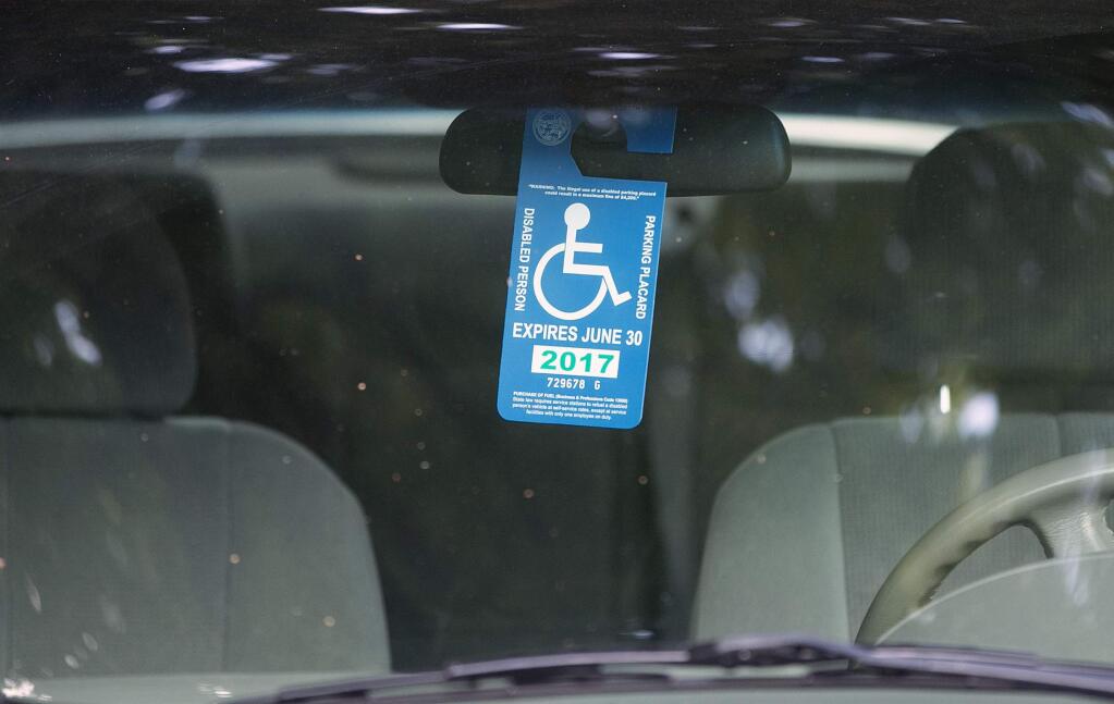 FILE - In this April 18, 2017, file photo, a handicapped placard hangs in a vehicle parked by the Capitol in Sacramento, Calif. California officials plan to crack down on thousands of 'dead' drivers who still hold disabled parking placards. (AP Photo/Rich Pedroncelli, File)