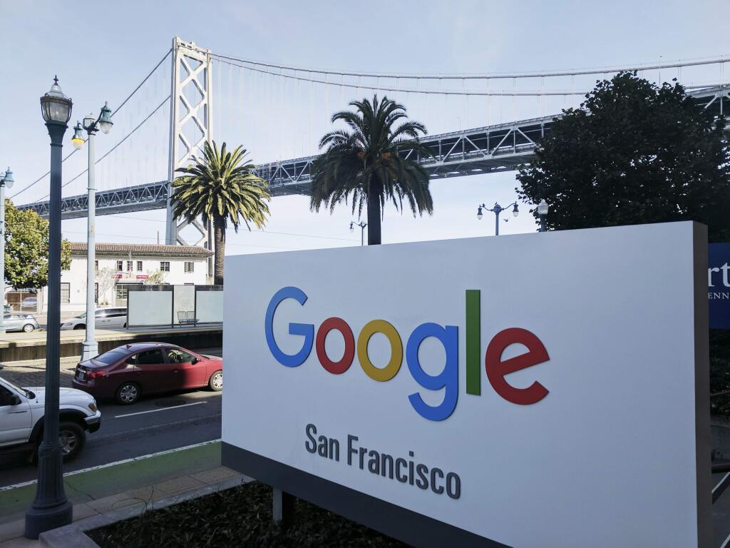FILE - In this Oct. 31, 2018, file photo shows signage outside the offices of Google in San Francisco with the San Francisco-Oakland Bay Bridge in the background. Four workers fired from Google in November 2019 are planning to file charges against the company with a federal agency. They are claiming the company unfairly retaliated against them for organizing workers around social causes. (AP Photo/Michael Liedtke, File)