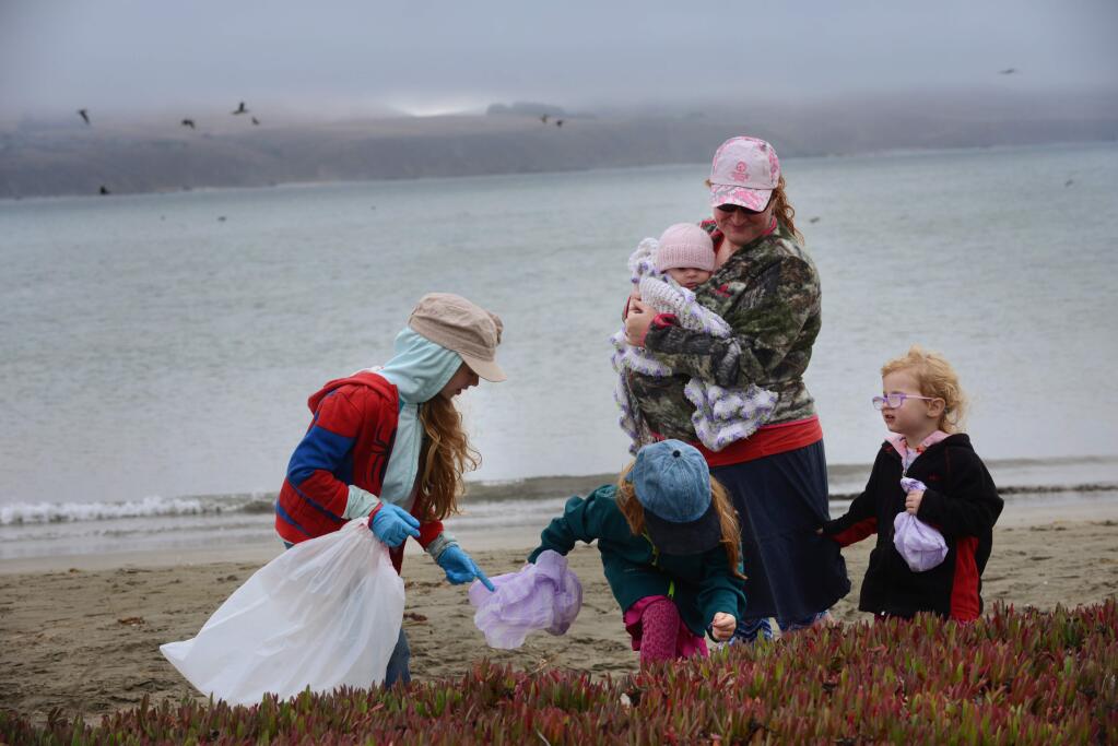 Tiffany Stenberg holding 8-month old Esther Stenberg while her three other daughters, from left, Maggie, 8, Priscilla, 5, and Anna, 3, collect trash near the shore at Doran Regional Park during California Coastal Cleanup on Saturday morning. The cleanup day is part of a statewide effort to remove trash from the California coast and inland waterways. September 15, 2018.(Photo: Erik Castro/for The Press Democrat)