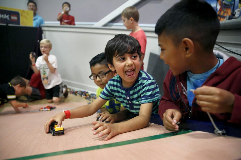 Arya Rasouli, 5, center, looks with excitement to Christian Navarro, 9, as they prepare to race LEGO cars during the Brick Palooza LEGO Festival at the Santa Rosa Veterans Memorial building on Sunday, November 13, 2016 in Santa Rosa, California . (BETH SCHLANKER/ The Press Democrat)