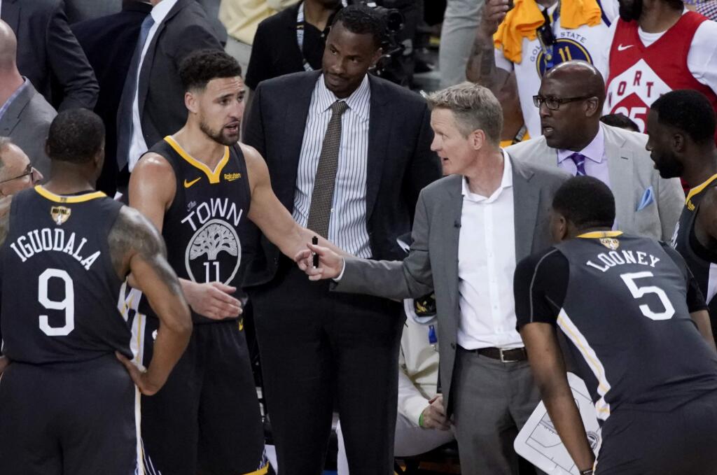 Golden State Warriors head coach Steve Kerr, middle right, talks with guard Klay Thompson during the second half of Game 4 of the NBA Finals against the Toronto Raptors in Oakland, Friday, June 7, 2019. (AP Photo/Tony Avelar)