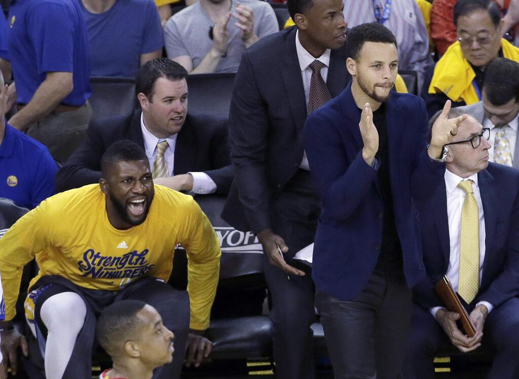 Golden State Warriors center Festus Ezeli, left, and guard Stephen Curry react during the first half in Game 1 of a second-round NBA basketball playoff series against the Portland Trail Blazers in Oakland, Calif., Sunday, May 1, 2016. (AP Photo/Jeff Chiu)
