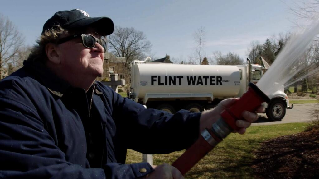 Filmmaker Michael Moore takes on President Trump in his new film, 'Fahrenheit 11/9,' as well as the failures of the Democratic establishment and th media. One of the sub-stories is about the ongoing water crisis in Flint, Mich., Moore's hometown. Here he is shown staging a stunt, hosing down the governor's mansion with a Flint Water truck and attempting to make a citizen's arrest. (Briarcliff Entertainment)