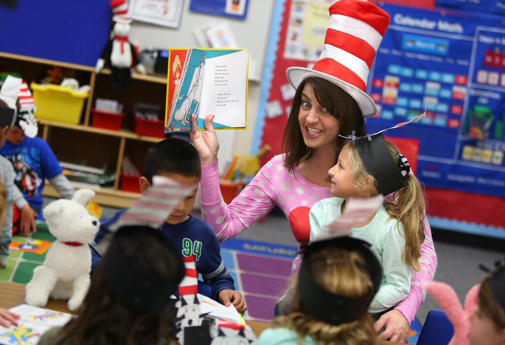 Transitional kindergarten teacher Michele Ferretti, center, reads Dr. Seuss' 'One Fish Two Fish Red Fish Blue Fish' to Ava Roach, right, David Vasquez-Valentin, and other students in her class, during Read Across America at Mattie Washburn elementary school, in Windsor on Monday, March 2, 2015. (Christopher Chung/ The Press Democrat)
