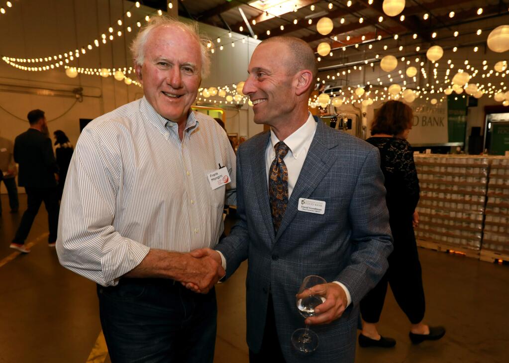 David Goodman, CEO of Redwood Empire Food Bank, right, shakes hands with Frank Mongini of Calistoga, at the 9th Annual Empty Bowls Dinner & Auction, a benefit to help end hunger at Redwood Empire Food Bank, in Santa Rosa, on Saturday, April 27, 2019. (Photo by Darryl Bush / For The Press Democrat)