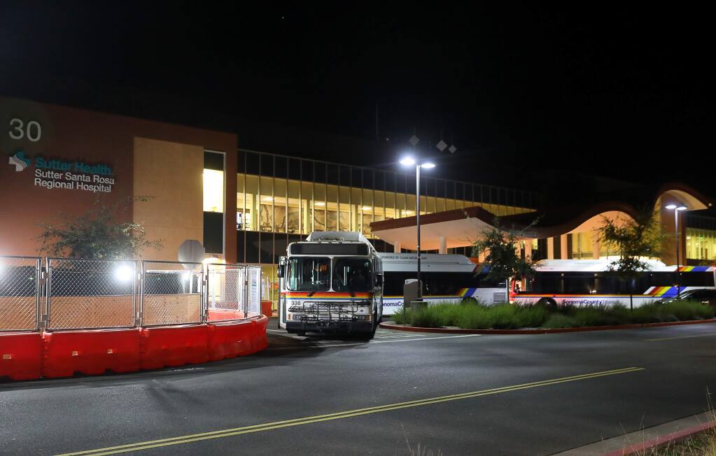 Buses arrive to evacuate patients and personnel from Sutter Santa Rosa Regional Hospital, due to the Kincade fire, in Santa Rosa on Saturday, October 26, 2019. (Christopher Chung/ The Press Democrat)