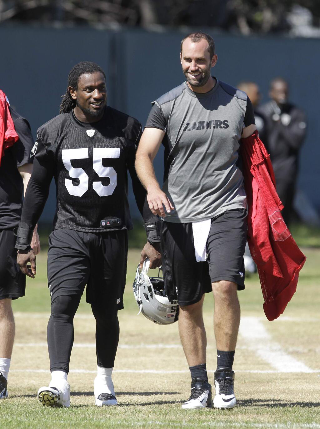Oakland Raiders quarterback Matt Schaub, right, walks off the field with linebacker Sio Moore after practice at the Raiders mini camp in Alameda, Calif., Wednesday, June 18, 2014.(AP Photo/Rich Pedroncelli)