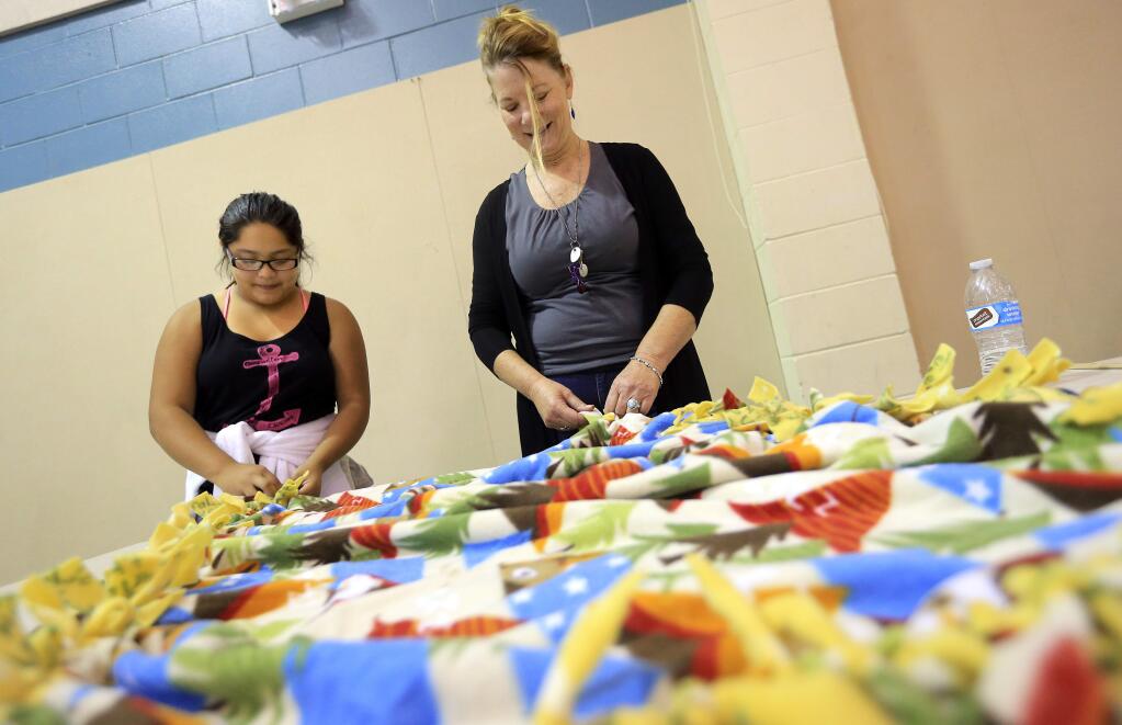 Mentor Katy Shetka, right, works on a blanket with Evelyn Martinez, 11, at Altamira Middle School in Sonoma on Thursday, October 13, 2016. The Sonoma Mentoring Alliance will donate the blankets to the Valley of the Moon Children's Home. (John Burgess/The Press Democrat)