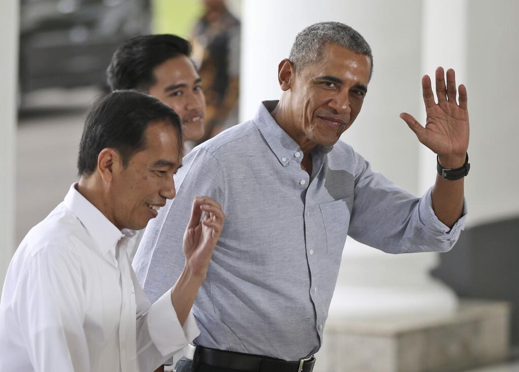 FILE - In this June 30, 2017, file photo, former U.S. President Barack Obama waves to reporters as he walks with Indonesian President Joko Widodo, left, upon arrival for their meeting at the Bogor Presidential Palace in Bogor, West Java, Indonesia. Obama's Aug. 12, 2017, tweet in response to the violence in Charlottesville, Virginia, is already one of the platform's most-liked posts.(AP Photo/Dita Alangkara, Pool, File)