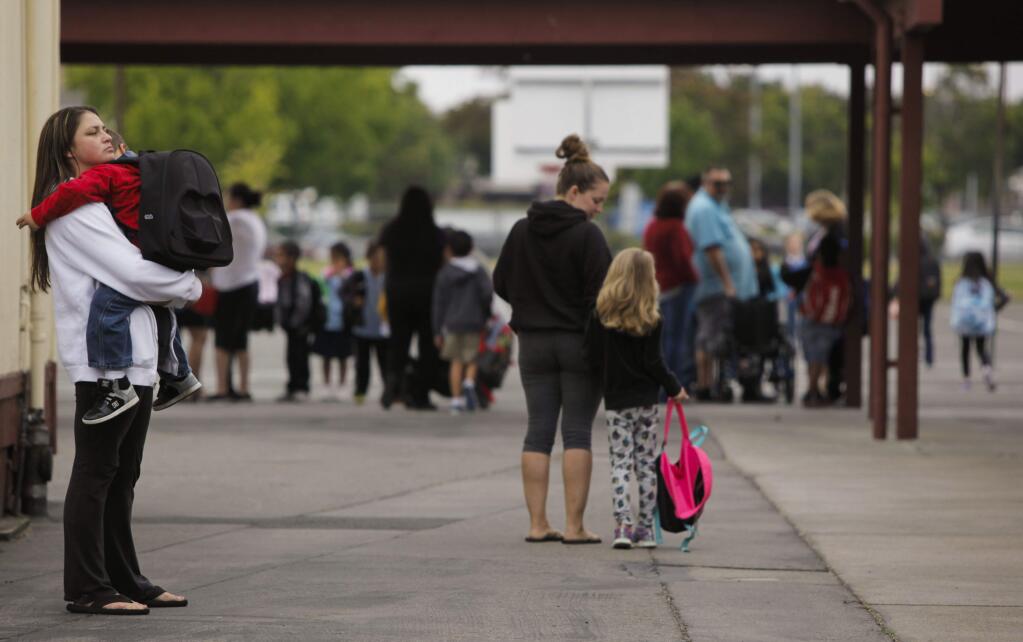 Shauna Wagner held Shyler Medeiros, 7, until the bell rang. He had a tough time coming back to school for his first day in first grade at McDowell Elementary. (CRISSY PASCUAL/ARGUS-COURIER STAFF)