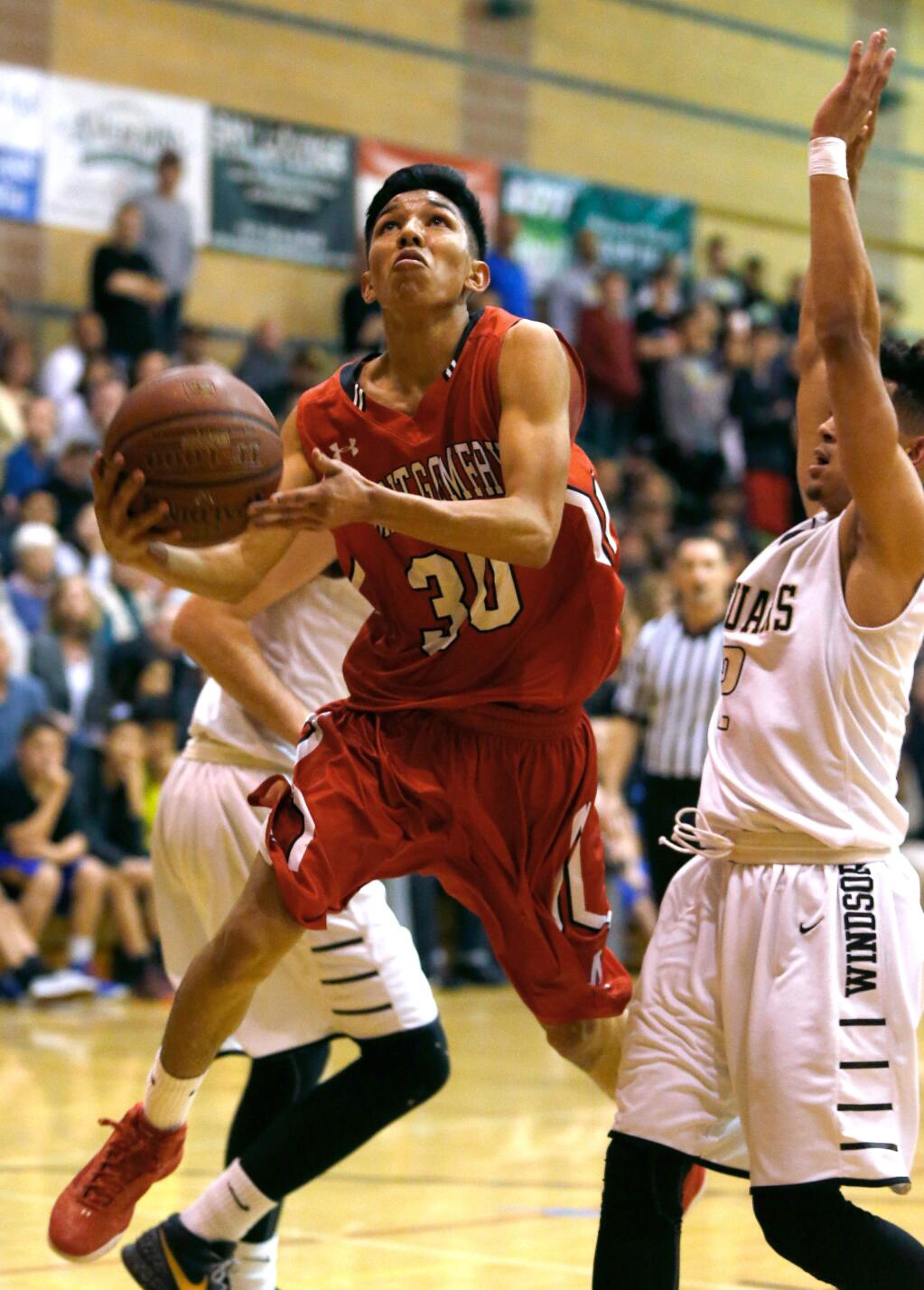 Montgomery's Alex Soria (30) goes for a layup while defended by Windsor's Chaise Noles (2), right, during the first half of the NCS Division 2 boys basketball quarterfinal game between Montgomery and Windsor high schools in Windsor, California, on Friday, February 26, 2016. (Alvin Jornada / The Press Democrat)