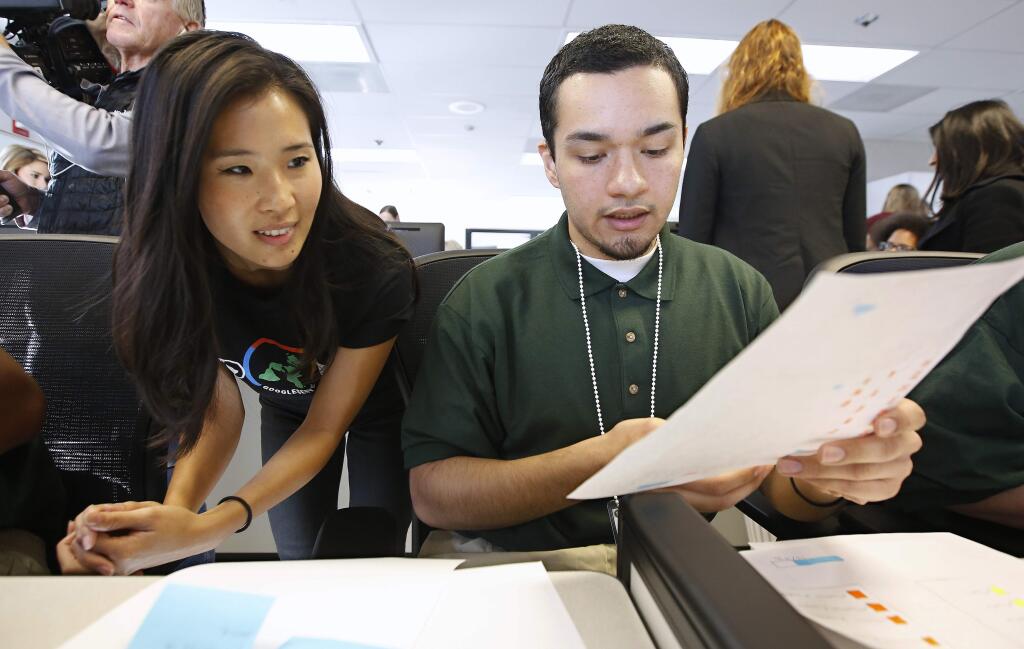 Ashley Ma, left, a senior digital visual designer with Google, reviews a website design done by Osvaldo Moreno Jr., a youth offender at the O.H. Close Youth Correctional Facility, Tuesday, Jan. 22, 2019, in Stockton, Calif. Gov. Gavin Newsom toured the facility and visited the class that teaches computer coding. Newsom is proposing to put California's juvenile prisons under the state's Health and Human Services Agency instead of the same agency that runs adult prisons. (AP Photo/Rich Pedroncelli)