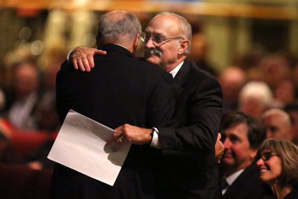 Brothers Mark, right, and Victor Trione embrace following Victor's speech at the celebration of life of their father, Henry Trione, at the Wells Fargo Center for the Arts, in Santa Rosa on Tuesday, February 17, 2015. (Christopher Chung/ The Press Democrat)