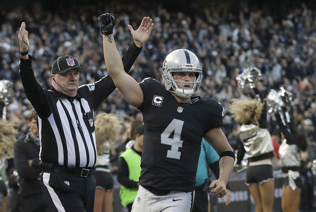 FILE - In this Nov. 27, 2016, file photo, Oakland Raiders quarterback Derek Carr (4) celebrates after throwing for a two-point conversion against the Carolina Panthers during the second half of an NFL football game, in Oakland, Calif. (AP Photo/Marcio Jose Sanchez, File)