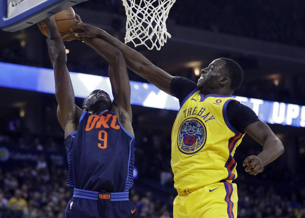 Golden State Warriors' Draymond Green, right, defends on Oklahoma City Thunder's Jerami Grant (9) during the first half of an NBA basketball game Saturday, Feb. 24, 2018, in Oakland, Calif. (AP Photo/Marcio Jose Sanchez)