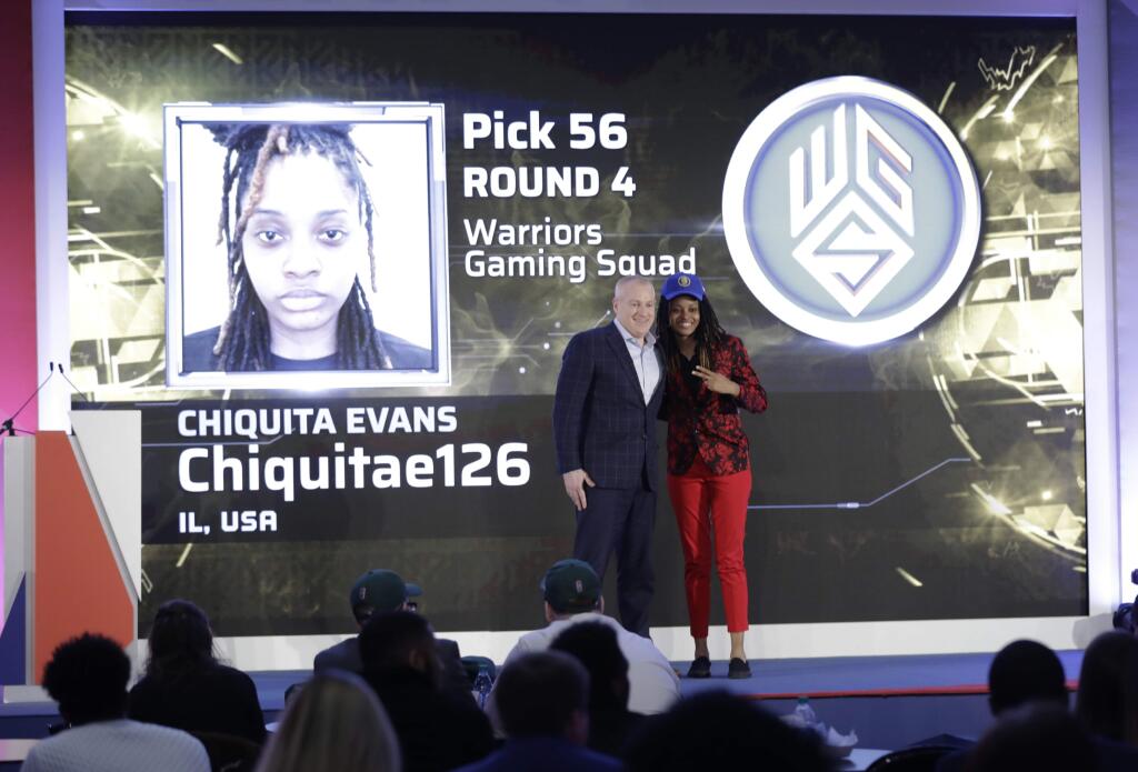 Chiquita Evans poses for photographs with Brendan Donohue after being selected as the 56th pick overall by the Warriors Gaming Squad at the NBA 2K League draft Tuesday, March 5, 2019, in New York. Evans is the first woman selected in the esports league. (AP Photo/Frank Franklin II)