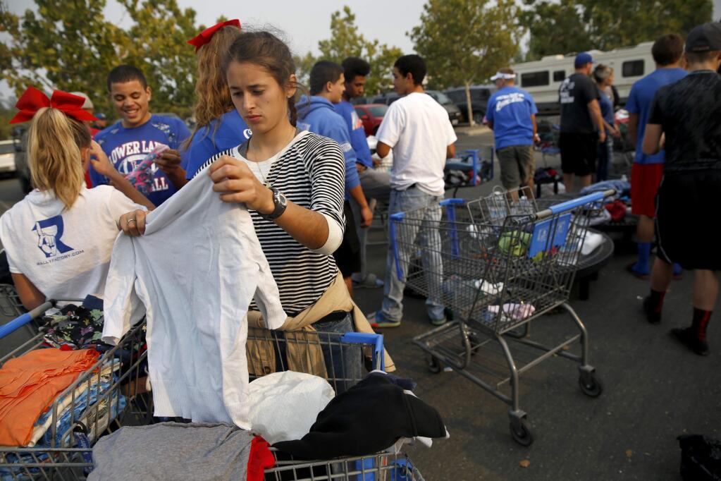 Gabby Jauregui and fellow Lower Lake High School students help sort clothing donations for Valley fire evacuees. (BETH SCHLANKER/ The Press Democrat)