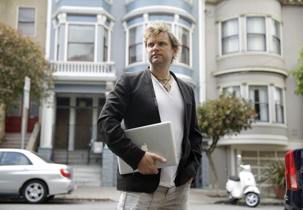 In this photo taken Wednesday, July 16, 2014, Gerry Kelly, founder of clothing brand Sonas Denim and a Bubblews user, poses near his home in San Francisco. Kelly has already earned nearly $100 from Bubblews since he began using a test version in January. His Bubblews feed serves as a journal about the lessons he has learned in life, as well as a forum for his clothing brand. (AP Photo/Eric Risberg)