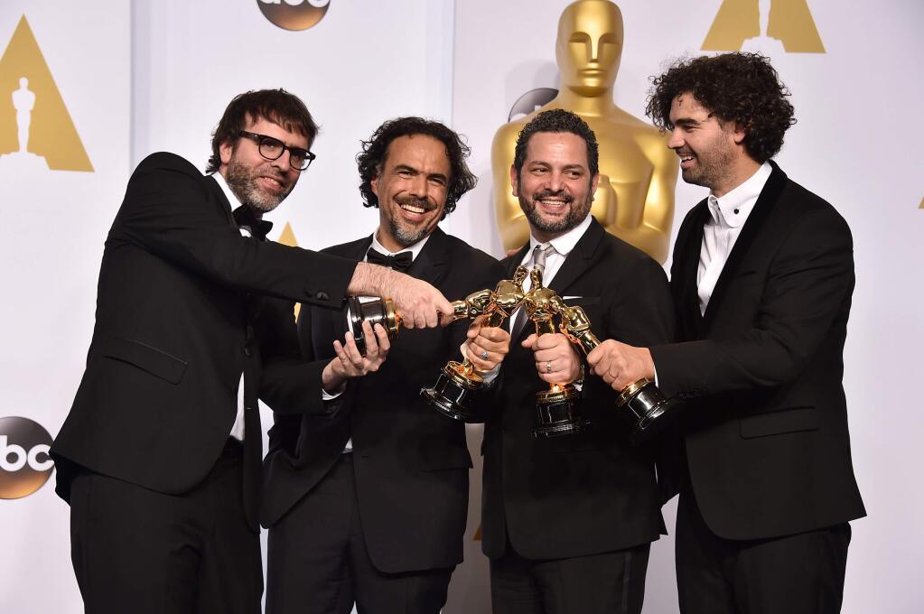 Nicolas Giacobone, and from left, Alejandro Gonzalez Inarritu, Alexander Dinelaris and Armando Bo pose in the press room with the award for the best picture for Birdman' at the Oscars on Sunday, Feb. 22, 2015, at the Dolby Theatre in Los Angeles. (Photo by Jordan Strauss/Invision/AP)