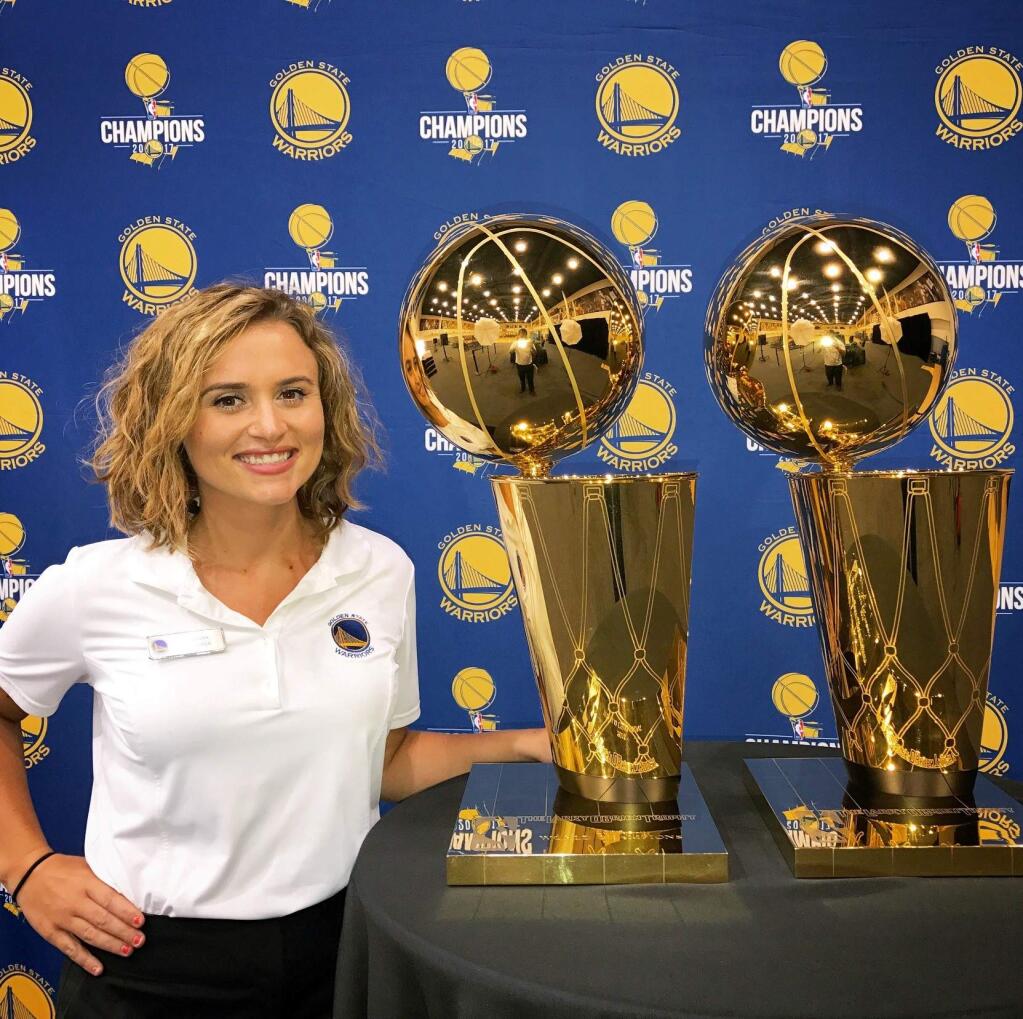 SUBMITTED PHOTOMegan Cooper with the Golden State Warriors world championship trophies. Cooper has worked behind the scenes for the Warriors for six years, and for a number of other Bay Area sports teams, including the 49ers and Giants.
