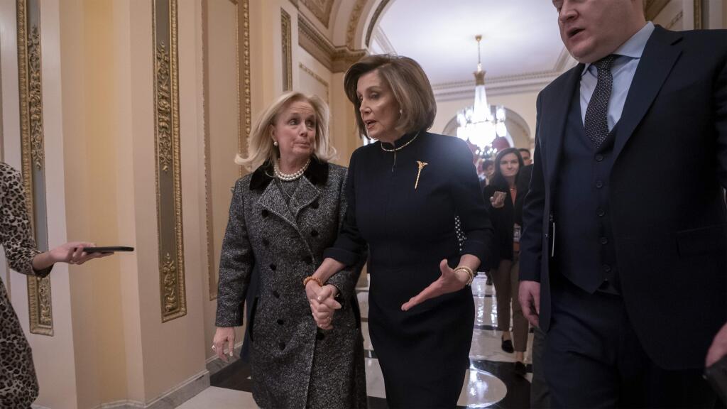 Speaker of the House Nancy Pelosi, D-Calif., holds hands with Rep. Debbie Dingell, D-Mich., as they walk to the chamber where the Democratic-controlled House of Representatives begins a day of debate on the impeachments charges against President Donald Trump for abuse of power and obstruction of Congress, at the Capitol in Washington, Wednesday, Dec. 18, 2019. (AP Photo/J. Scott Applewhite)