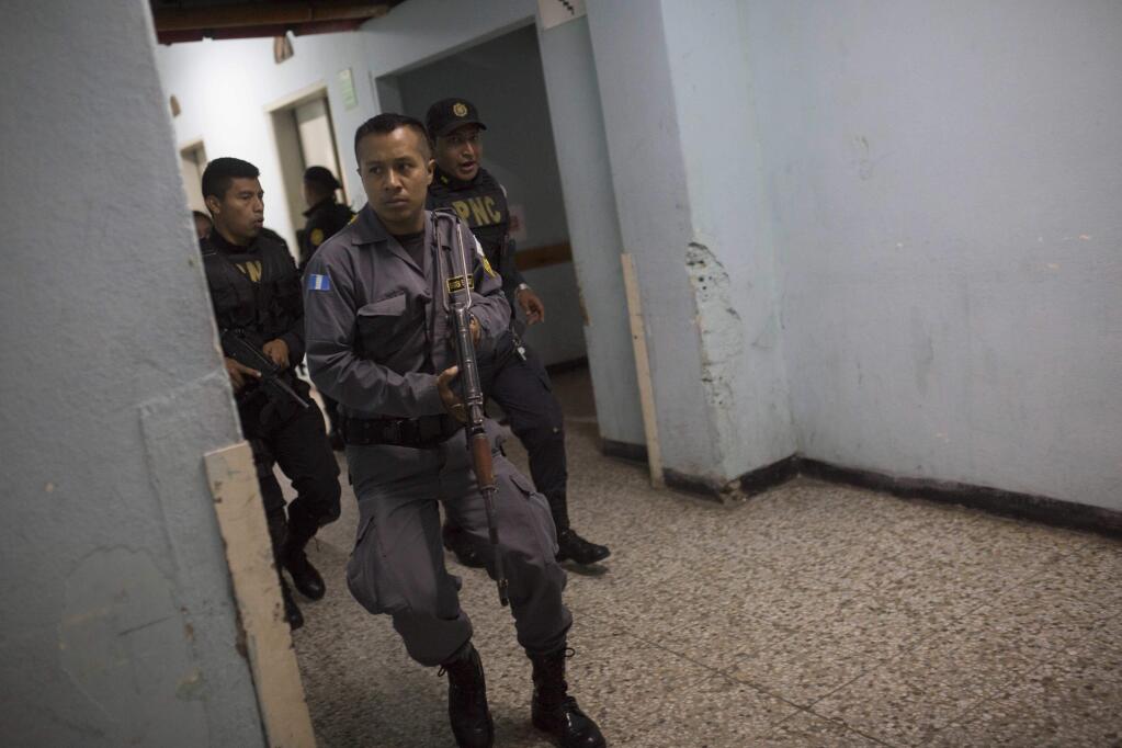 Police go room to room searching for attackers at the Roosevelt Hospital in Guatemala City, Wednesday, Aug. 16, 2017. Officials in Guatemala say at least two people have been killed and five arrested in an early morning shooting at the Roosevelt, one of the country's largest hospitals, where an unknown number of attackers entered the hospital and began shooting. (AP Photo/Luis Soto)