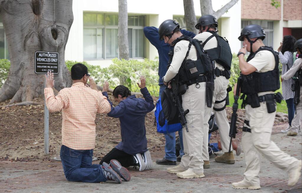 SWAT officers search students who were evacuated from the UCLA campus near the scene of a fatal shooting at the University of California, Los Angeles, Wednesday, June 1, 2016, in Los Angeles. (AP Photo/Damian Dovarganes)