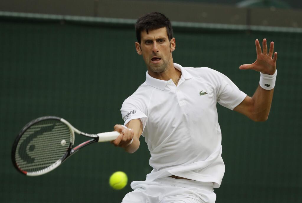 Novak Djokovic of Serbia returns the ball to Karen Khachanov of Russia during their men's singles match on the seventh day at the Wimbledon Tennis Championships in London, Monday July 9, 2018. (AP Photo/Kirsty Wigglesworth)