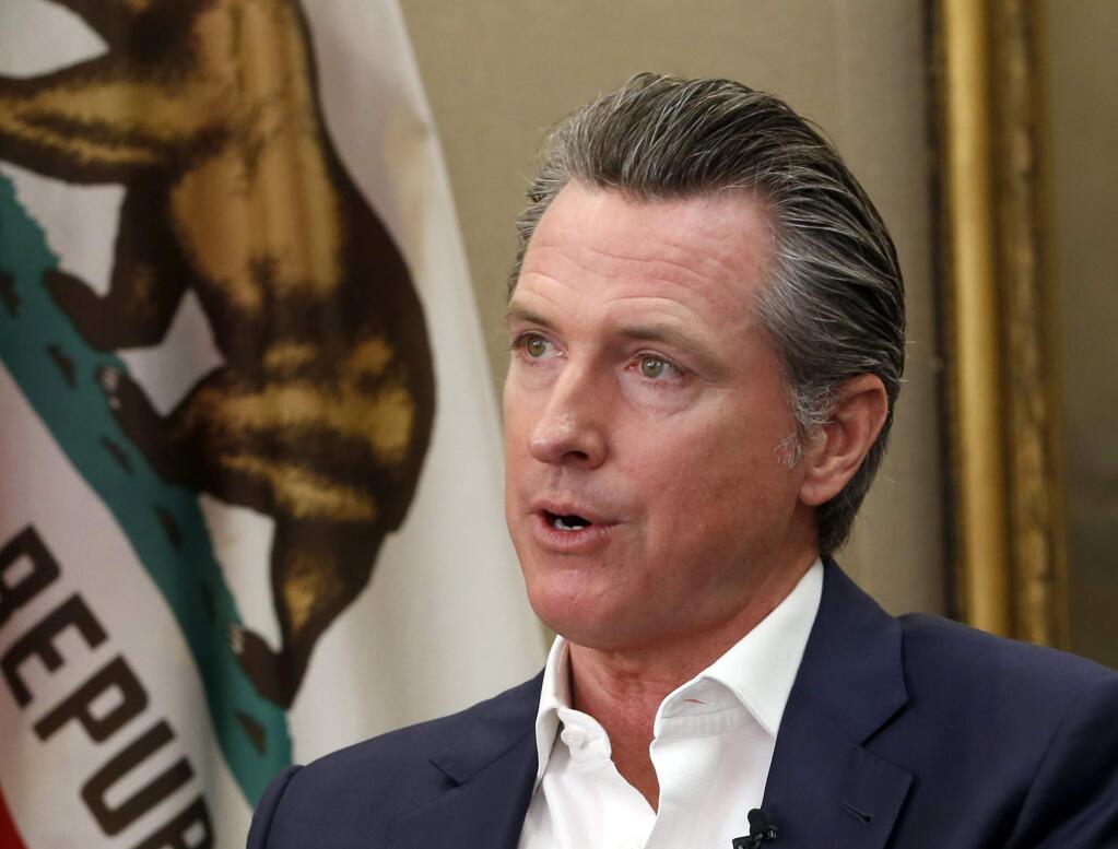 FILE - This Oct. 8, 2019, file photo, shows California Gov. Gavin Newsom during an interview in his office at the Capitol in Sacramento, Calif. California's governor is pardoning three more immigrants facing the possibility they will be deported. They are among four pardons and two commutations of youthful offenders announced Friday, Oct. 18, 2019, by Newsom. Newsom's office says the three facing deportation have served their sentences and deporting them now would be 'an unjust collateral consequence.' The three hail from Iran, El Salvador and Cambodia. (AP Photo/Rich Pedroncelli, File)