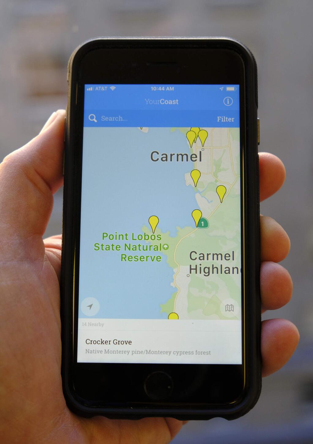 The new YourCoast app is displayed on a smartphone Thursday, Dec. 13, 2018, in San Francisco. The new smartphone app that shows users a map of more than 1,500 access points along the California coast was created with help from a tech billionaire whose elaborate wedding ran afoul of state regulators. The California Coastal Commission is unveiling the YourCoast app Thursday. (AP Photo/Eric Risberg)